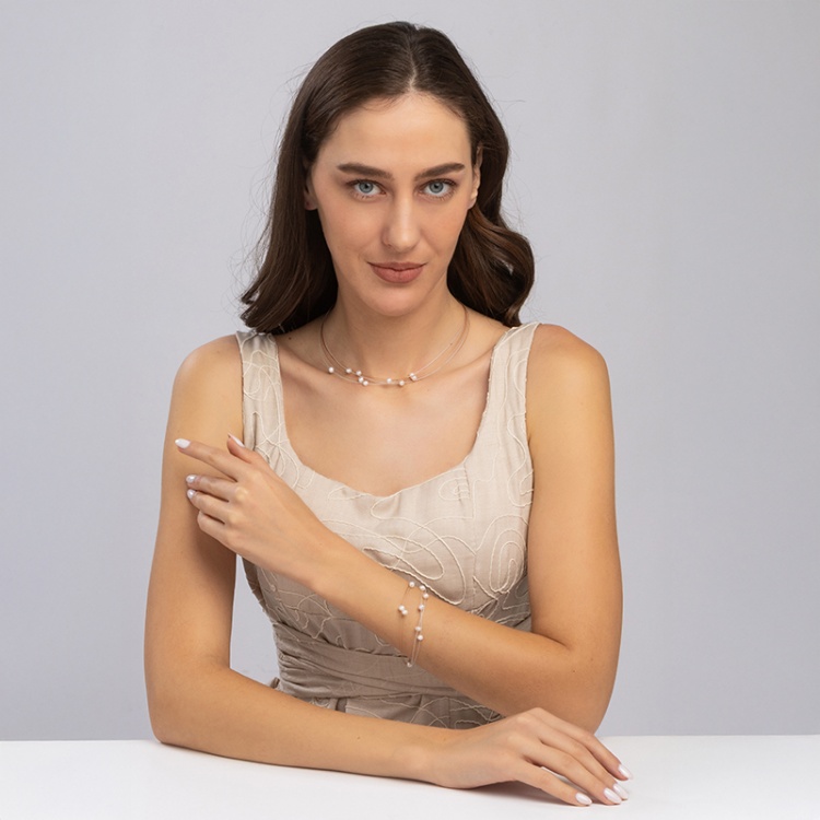 Гривна с бели перли върху кафява корда